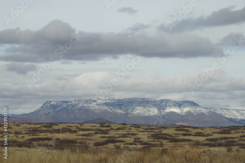 The desert scenery of Yavapai County, Arizona, with the red-rock of Sedona covered in snow in the background.