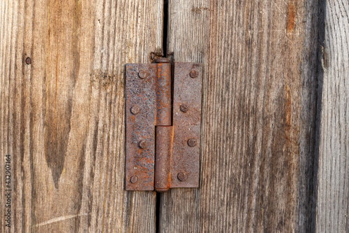 Old rusty metal door hinge. Door hinge on a wooden door.