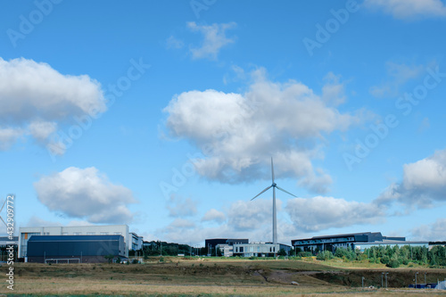 An electricity generating windmills in the countryside against blue cloudy sky