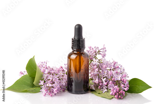 Cosmetic oil in lilac flowers. Cosmetics for body and face skin care. On white background. Isolate.