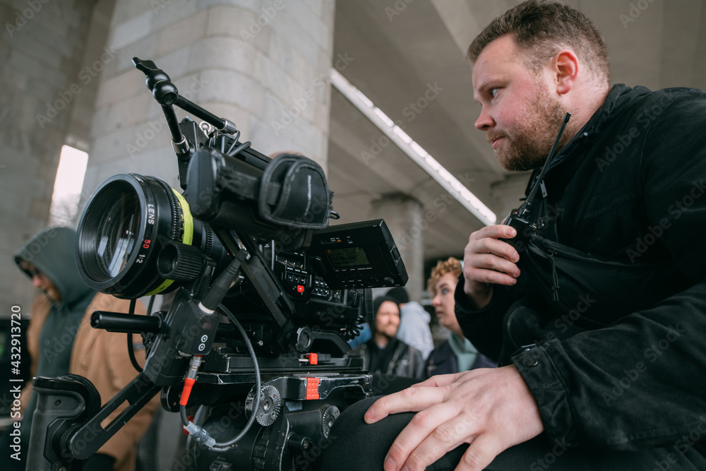 Director of photography with a camera in his hands on the set. Professional videographer at work on filming a movie Director of photography with a camera in his hands on the set. Professional videographer at work on filming a movie
