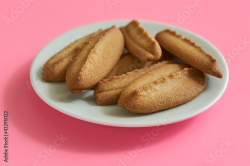 Baked cookies on white plate on pink background
