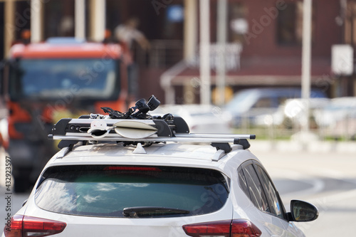  A trip to a ski resort. A fragment of the roof of a car with fixed snowboards. Selective focus.