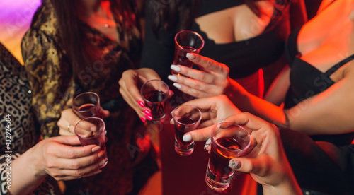 фотографія Clinking glasses with alcohol and toasting, party.