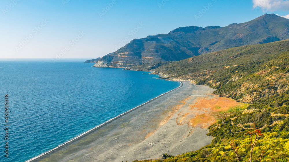 Nonza Beach. It is certainly the most original beach on the west coast of Corsica. It is located below the hilltop village of Nonza. It stretches for 1.4 km of small gray pebbles and black sand. Nonza Beach. It is certainly the most original beach on the west coast of Corsica. It is located below the hilltop village of Nonza. It stretches for 1.4 km of small gray pebbles and black sand.
