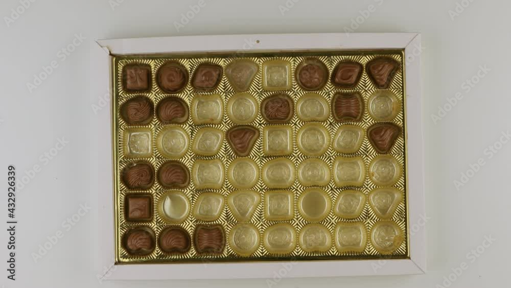 Taking pieces of candy from box of bonbon Taking pieces of candy from box of bonbon