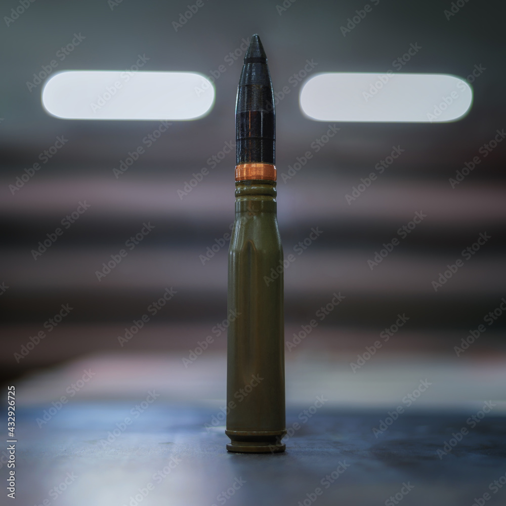 A large-caliber bullet on a blurry background. Weapon. A picture illustrating the weapon. A large-caliber bullet on a blurry background. Weapon. A picture illustrating the weapon.
