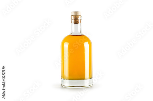Transparent bottle with golden alcohol liquid inside isolated on white background.