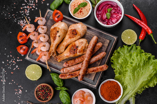 Composition of sausages, chicken, pork and shrimp prepared on grill, as well as vegetables prepared on grill with spices and herbs