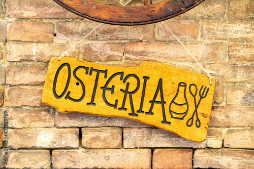 A wooden sign with the inscription Osteria photo