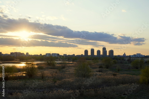 Sunset landscape with Vacaresti Delta natural park and residential buildings in Bucharest, Romania 