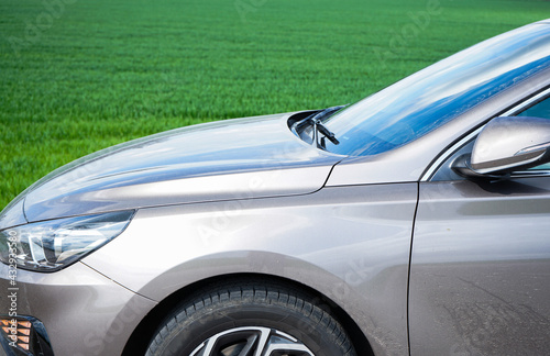 Fototapeta Naklejka Na Ścianę i Meble -  The car is parked in front of a young green field. Hyundai i30