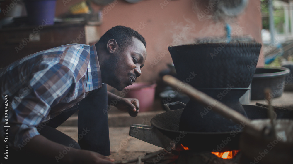 Native African man blowing the fire cook in the kitchen with happy.16:9 style Native African man blowing the fire cook in the kitchen with happy.16:9 style