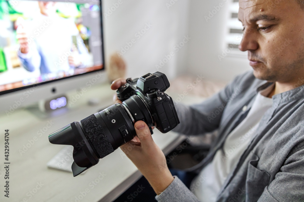 Accounting work in a marketing and advertising agency. A middle-aged man checks photos taken at the shooting, approval of materials for clients. Agency life, home office during corona virus time Accounting work in a marketing and advertising agency. A middle-aged man checks photos taken at the shooting, approval of materials for clients. Agency life, home office during corona virus time
