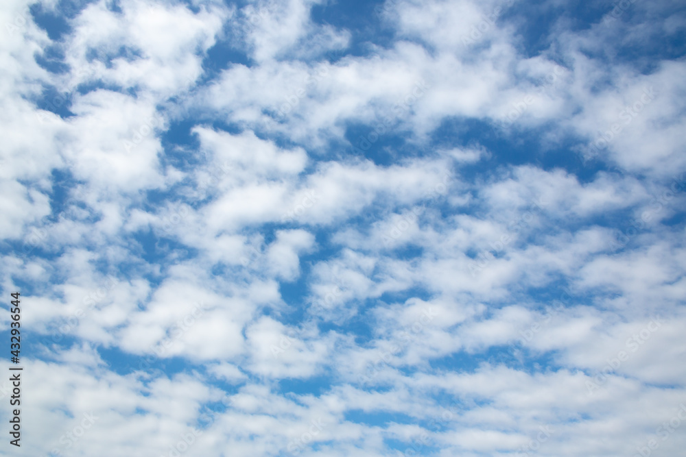 Fluffy white clouds against a blue sky background