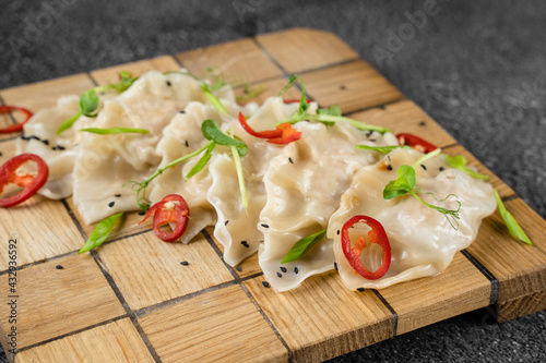 Jiaozi chinese dumplings named gyoza on wooden plate. Asian traditional fast food. Dough dish stuffed with meat and vegetables, less often only meat.