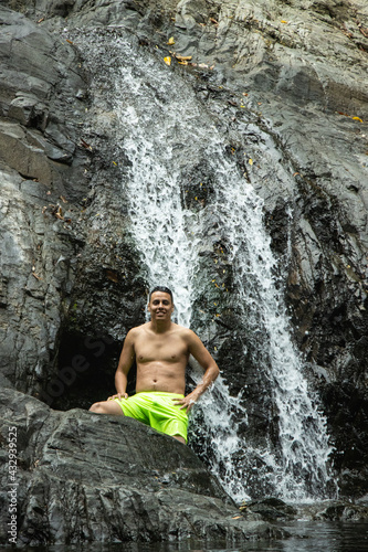 Hombre joven parado en una cascada