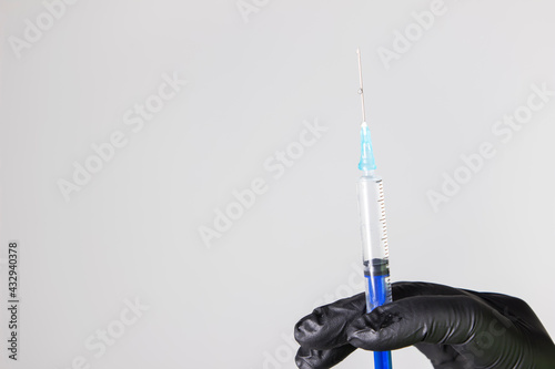 A hand holding a syringe with a dialed vaccine and medicine photo