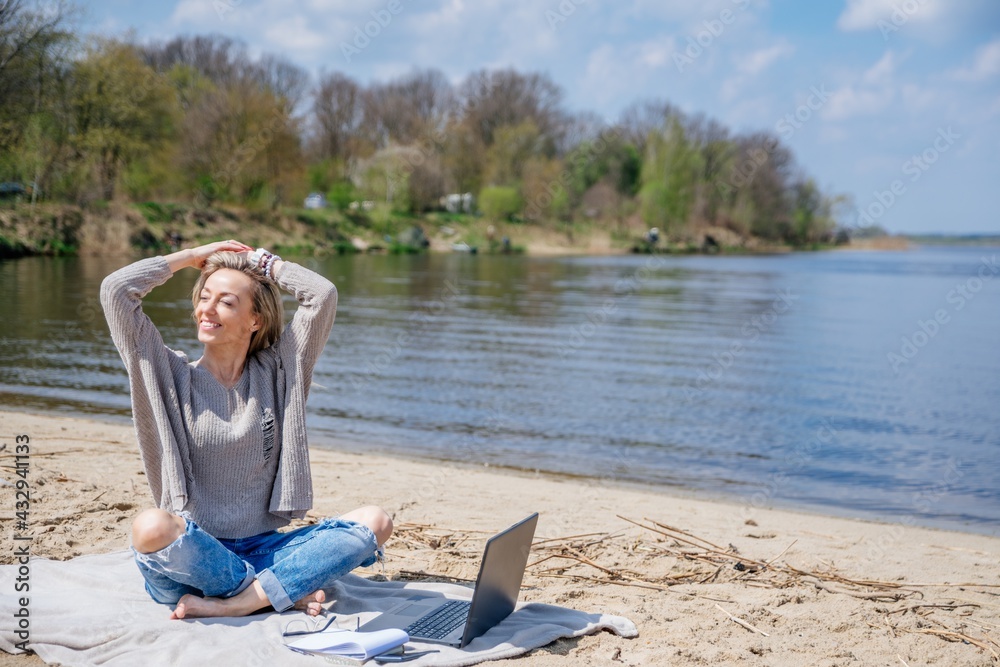 Beauty blonde woman enjoying freelance work on laptop. Freelance work, travel, vacations.