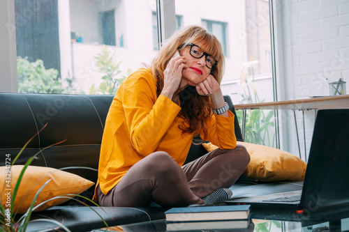 woman with mobile phone and computer at home photo