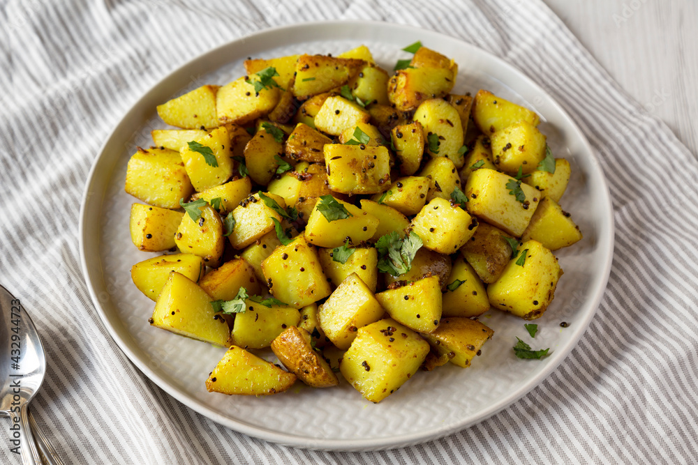 Homemade Roasted Potatoes with Mustard Seeds on a Plate, low angle view. Homemade Roasted Potatoes with Mustard Seeds on a Plate, low angle view.