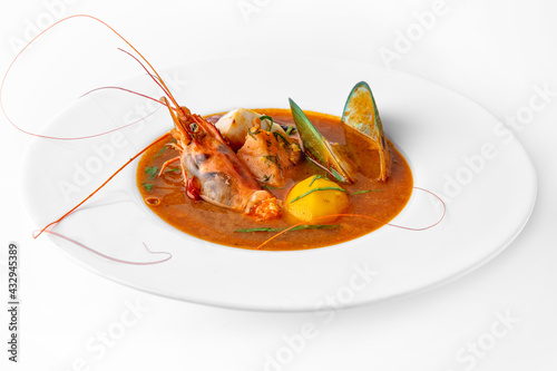 Delicate spicy cream seafood soup with shrimp, mussels, octopus and salmon. Banquet festive dishes. Gourmet restaurant menu. White background.