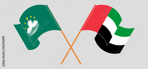 Crossed and waving flags of Macau and the United Arab Emirates