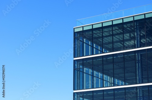 Exterior view of a vacant brand new modern office building. Typical glass facade of generic modern commercial building. Blue sky © MichaelVi