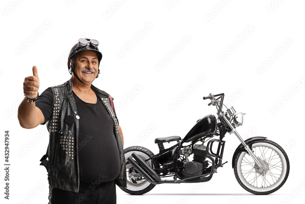Mature biker with a leather vest gesturing a thumb up in front of a chopper Mature biker with a leather vest gesturing a thumb up in front of a chopper