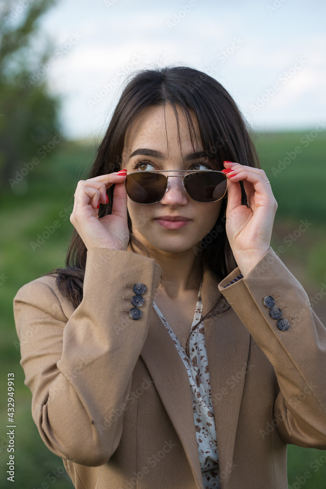 Portrait of a positive cheerful brunette girl in a green spring park. Portrait of a positive cheerful brunette girl in a green spring park.