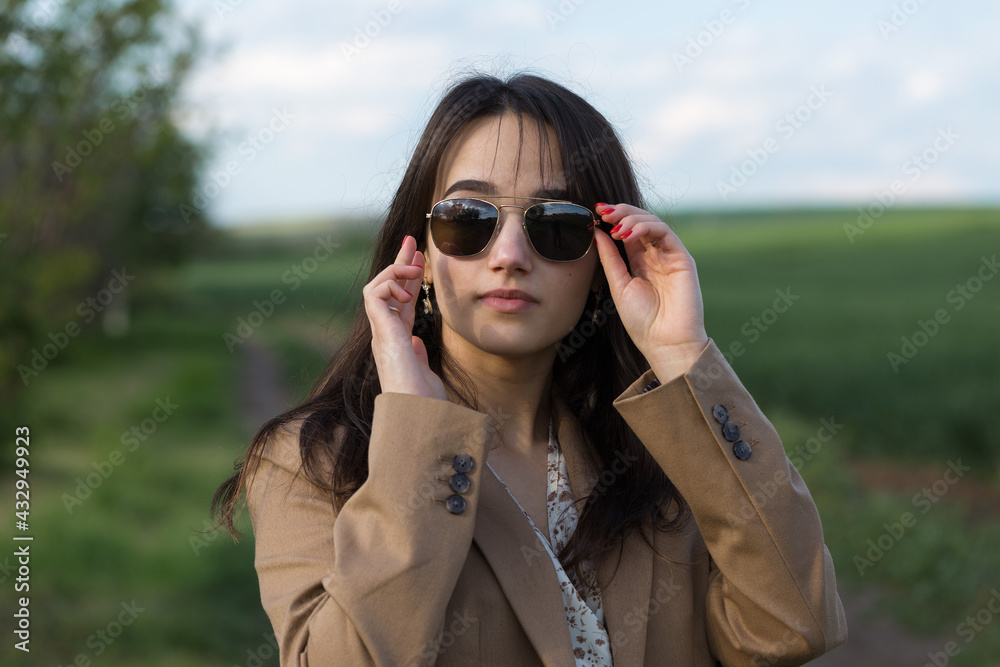 Portrait of a positive cheerful brunette girl in a green spring park. Portrait of a positive cheerful brunette girl in a green spring park.