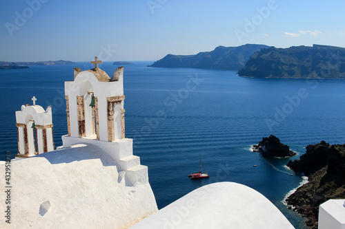 Bell towers of traditional Greek church against blue sea and sky, Oia, Santorini, Greece 