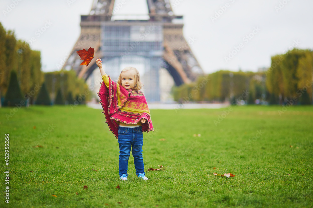 Adorable toddler girl near the Eiffel tower on a fall day in Paris, France Adorable toddler girl near the Eiffel tower on a fall day in Paris, France