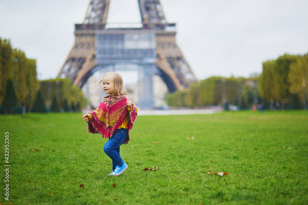 Adorable toddler girl near the Eiffel tower on a fall day in Paris, France Adorable toddler girl near the Eiffel tower on a fall day in Paris, France