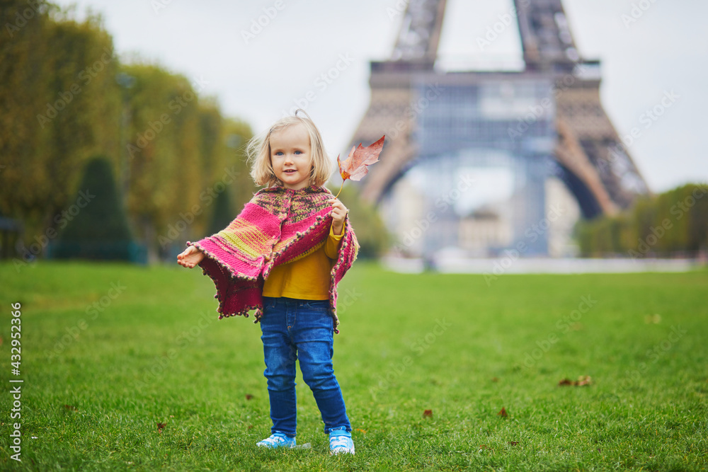 Adorable toddler girl near the Eiffel tower on a fall day in Paris, France Adorable toddler girl near the Eiffel tower on a fall day in Paris, France