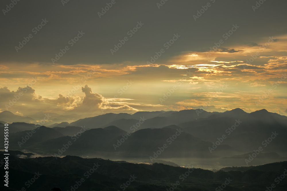Obraz premium Golden Sunset Landscape with mountains and fog