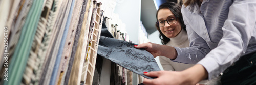 Seller demonstrates fabric samples to client closeup