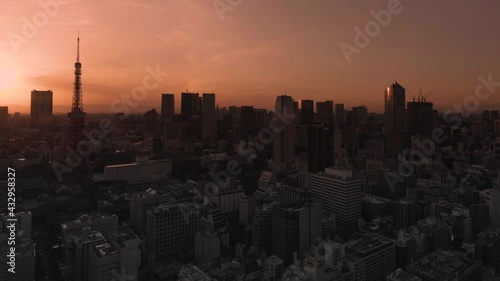 tokyo, japan - may 10 2021: Pan video of a cityscape of the Daimon district of Tokyo city with a sunset sky behind the Tokyo tower and Roppongi Hills skyscrapers. photo