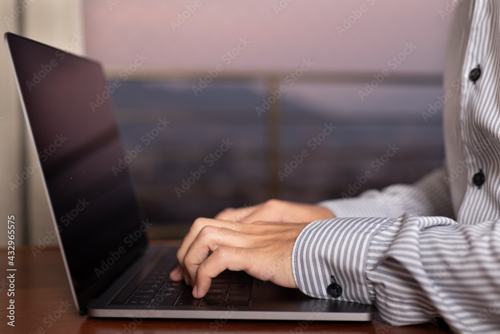 Close up of man hands typing on the computer with blurred background at sunset. Shopping on line concept Close up of man hands typing on the computer with blurred background at sunset. Shopping on line concept