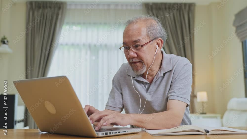 Asian old man working online at home during COVID-19 pandemic. Asian old man working online at home during COVID-19 pandemic.