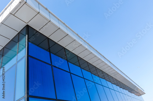 Fragment of the new, modern building with windows and blue stained-glass windows.