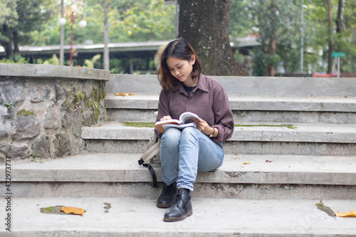 Young woman studying at the park. © faishalabdula