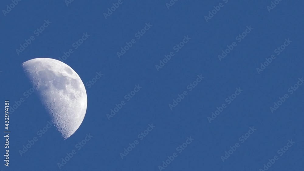 Fast-motion daytime closeup of quarter moon rising, against a cloudless blue sky. Fast-motion daytime closeup of quarter moon rising, against a cloudless blue sky.