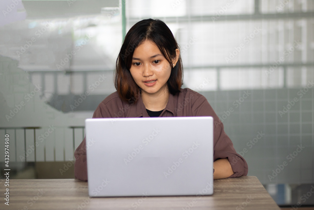 Attractive happy young girl student studying at the college library having video chat. Attractive happy young girl student studying at the college library having video chat.