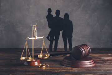 Family figures with judge's gavel and justice scales on dark wooden background