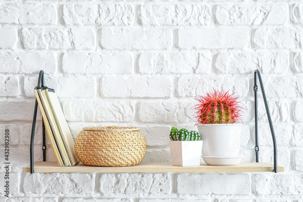 Modern shelf with decor hanging on brick wall Modern shelf with decor hanging on brick wall