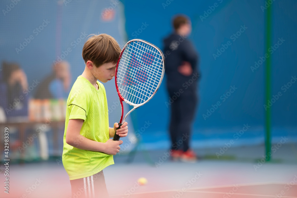 Sad boy in tennis competition. The child plays tennis.