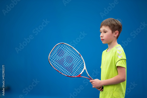 Little boy with a tennis racket. The child plays tennis.
