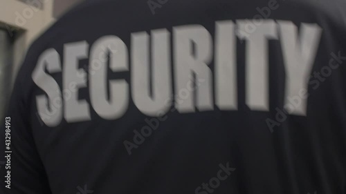 Rear view of a security guard in uniform patrolling in a commercial area. photo