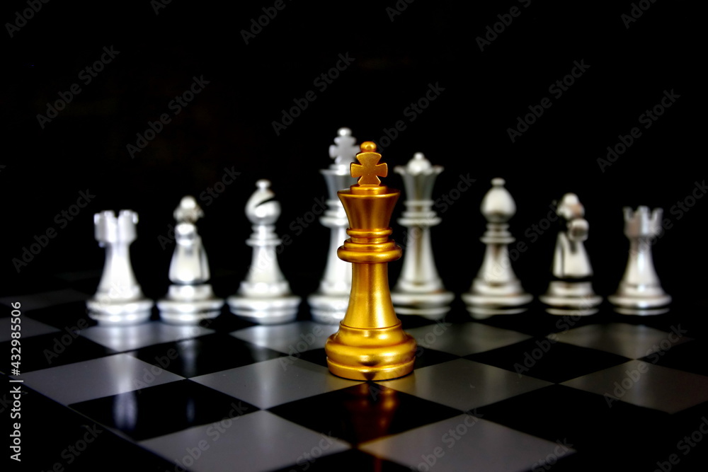 golden king chess in front of chess pieces on chess game board golden king chess in front of chess pieces on chess game board